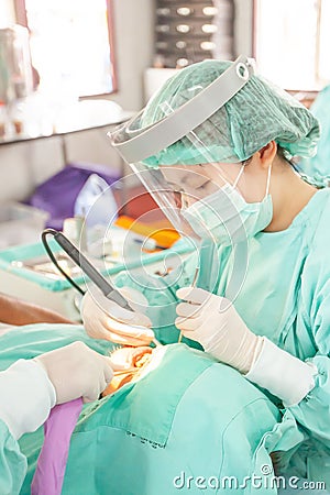 Medical officer examining a senior manâ€™s teeth in field hospital Editorial Stock Photo